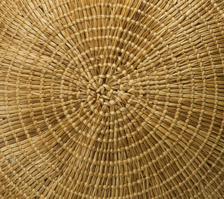 base of a large grass basket with a circular weaving pattern.