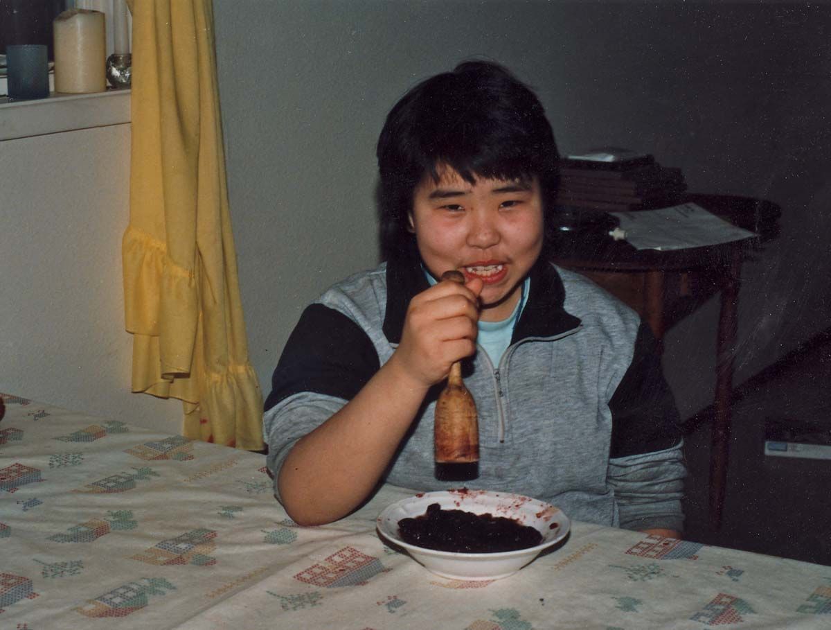 Person mashing a bowl of Lingonberries