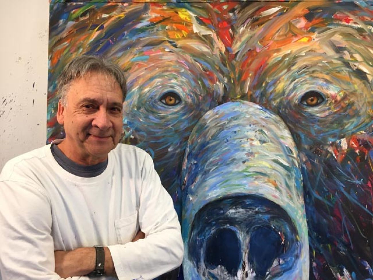 Man standing beside a painting of a bear