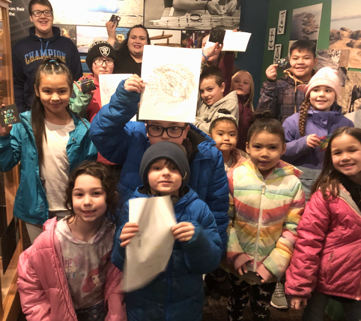 Salmon filets hanging from the rafters in a smokehouse